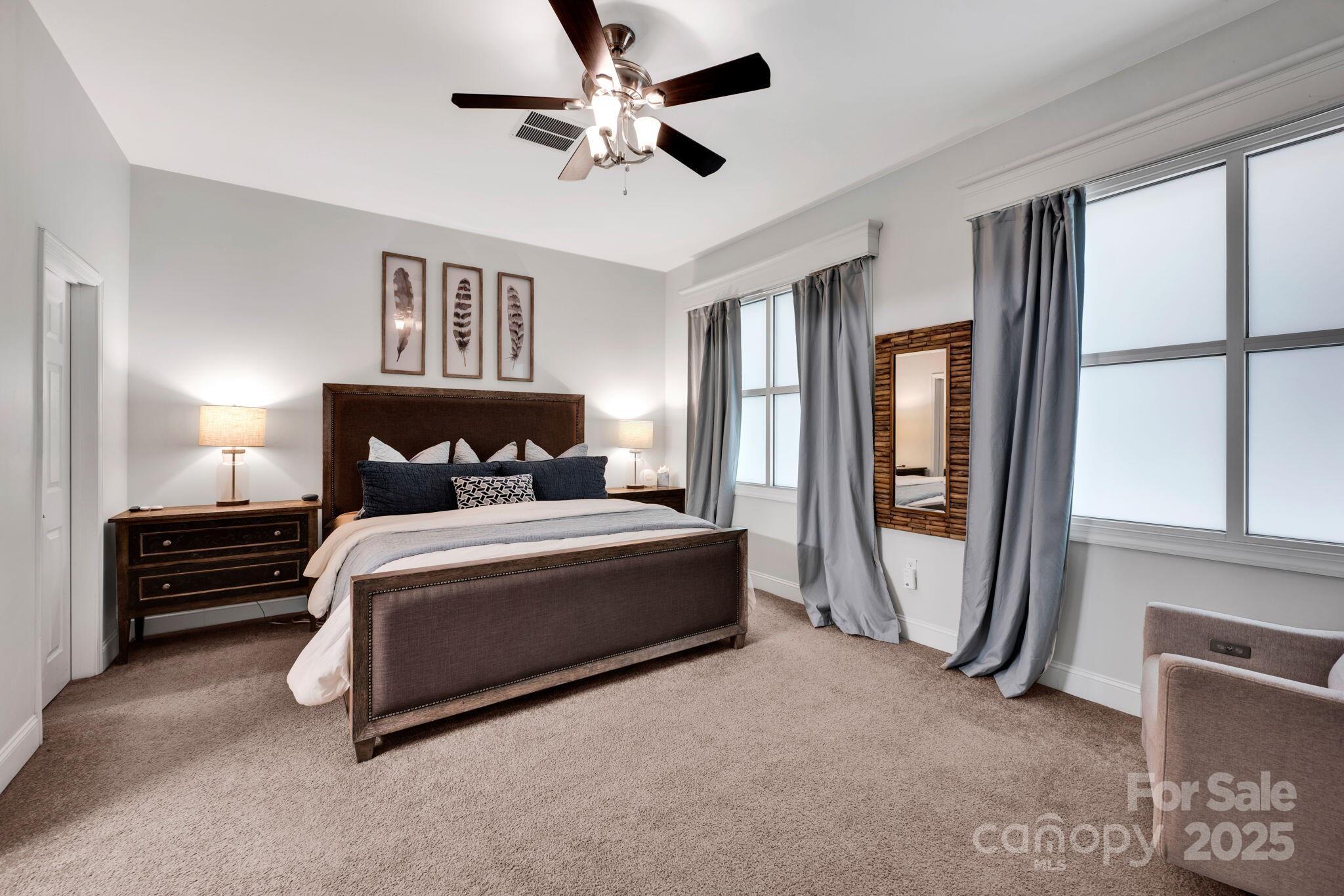 127 North Tryon Street, Unit 404 Charlotte, NC 28246 - Photo 5 of 22 a bedroom with a bed and a chandelier