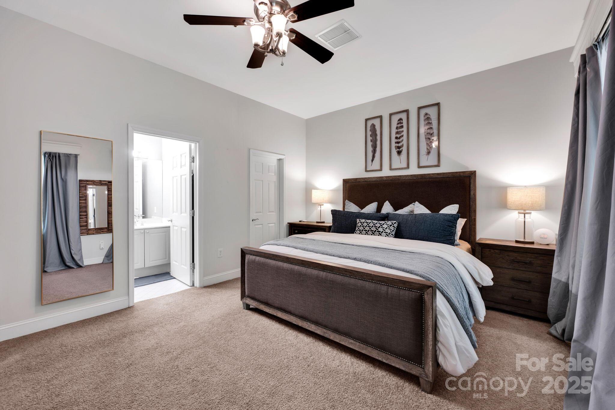 127 North Tryon Street, Unit 404 Charlotte, NC 28246 - Photo 6 of 22 a bedroom with a bed and a chandelier