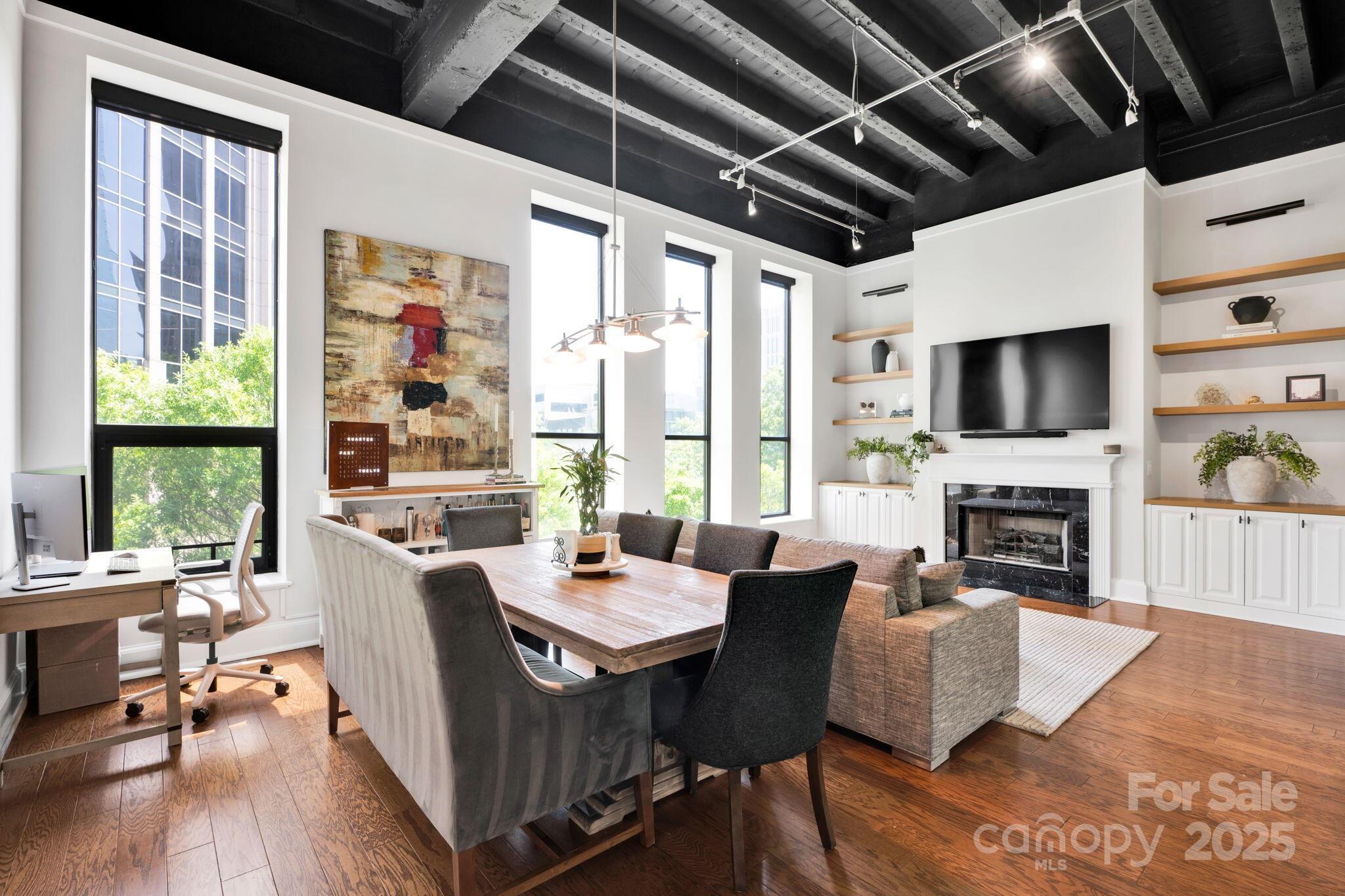 127 North Tryon Street, Unit 404 Charlotte, NC 28246 - Photo 9 of 22 a dining room with furniture a fireplace and wooden floor
