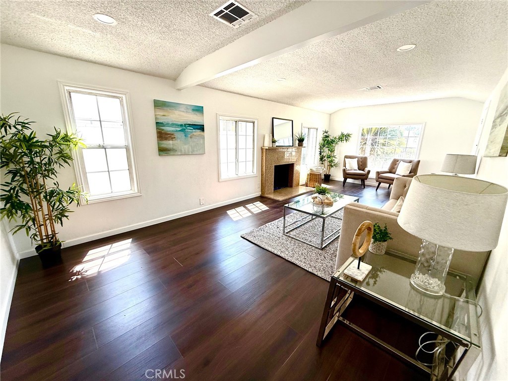 8231 Comolette Street Downey, CA 90242 - Photo 10 of 25 a living room with fireplace furniture and a wooden floor