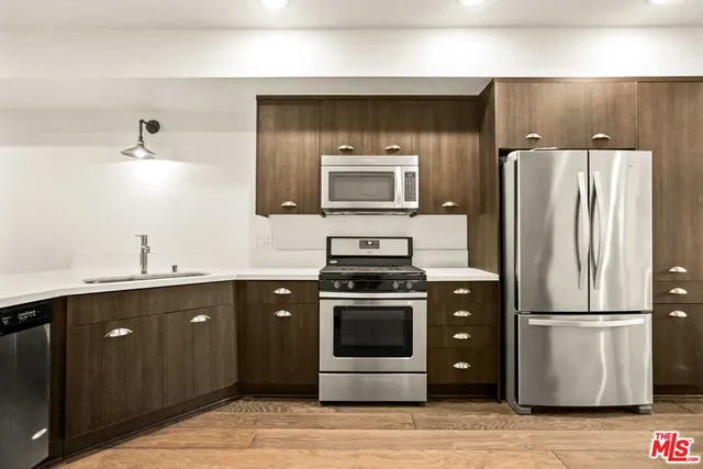a kitchen with a sink and stainless steel appliances