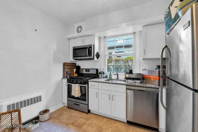 a kitchen with stainless steel appliances a sink stove refrigerator and cabinets