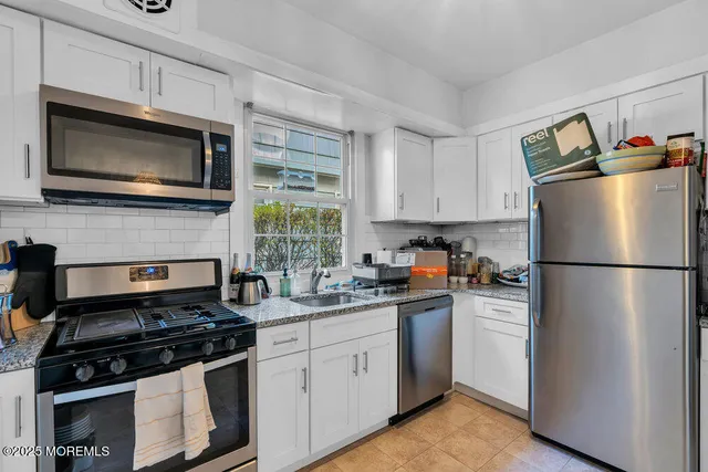 a kitchen with stainless steel appliances a stove microwave and a sink