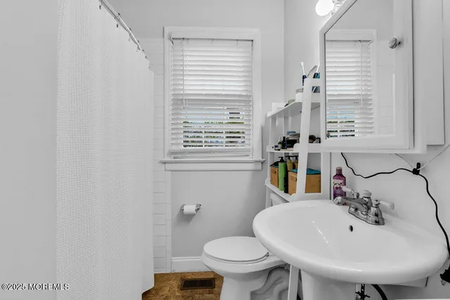 a bathroom with a sink a toilet and a mirror