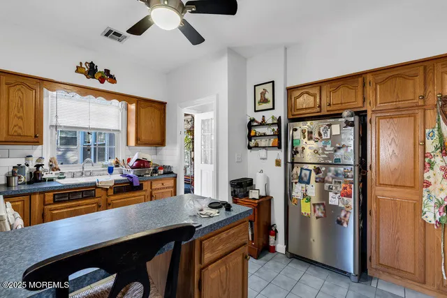 a room with stainless steel appliances granite countertop a refrigerator and a stove top oven