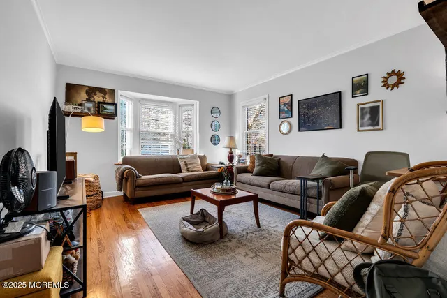 a living room with furniture a flat screen tv and a window