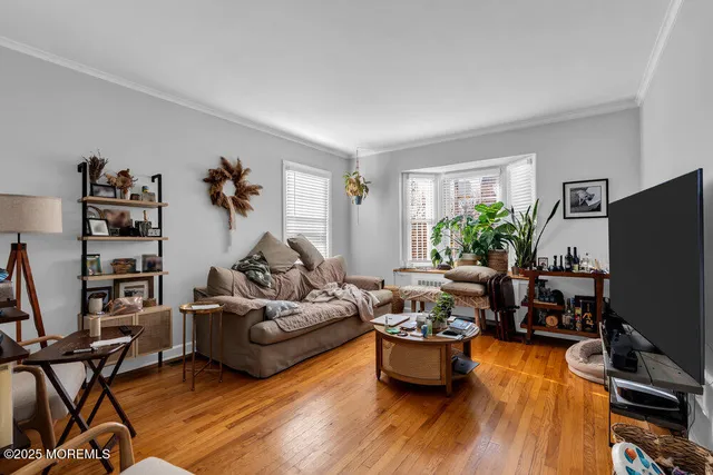 a living room with furniture flat screen tv and a window
