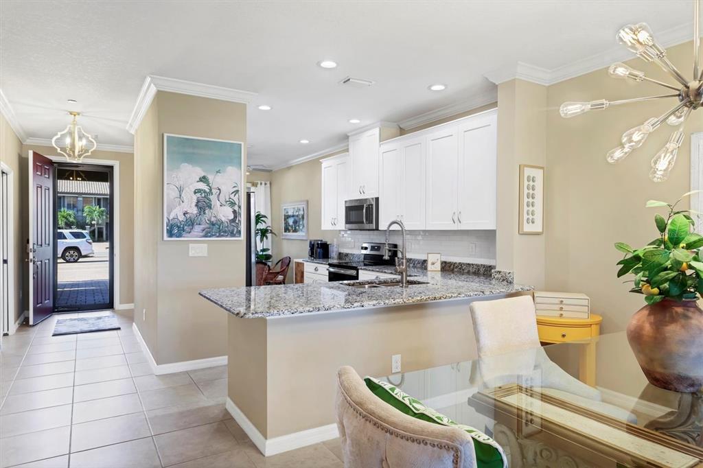 13703 Messina Loop, Unit 102 Bradenton, FL 34211 - Photo 13 of 74 a kitchen with stainless steel appliances kitchen island granite countertop a sink and cabinets
