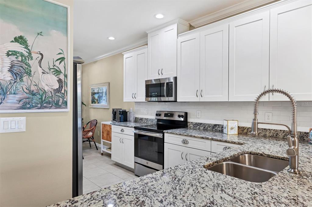 13703 Messina Loop, Unit 102 Bradenton, FL 34211 - Photo 14 of 74 a kitchen with stainless steel appliances granite countertop a sink stove and microwave