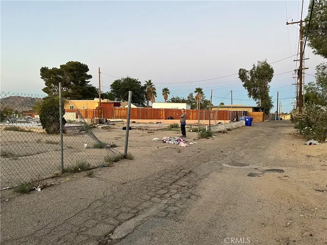 a view of a dry yard with wooden fence