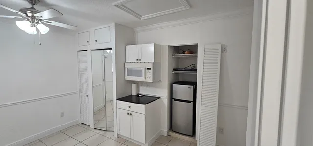 a room with white cabinets and white appliances