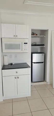 a kitchen with white cabinets and a refrigerator