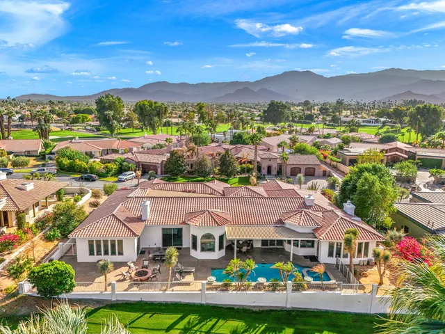 a front view of a city with lots of residential buildings and mountain view in back