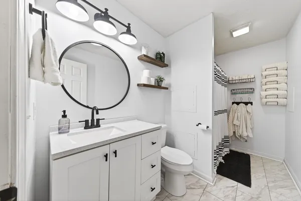 a bathroom with a toilet sink and mirror