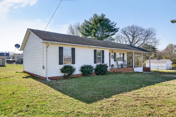a view of a house with backyard and garden