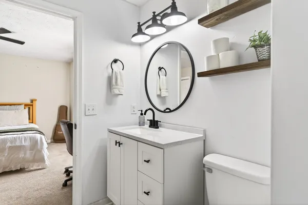 a bathroom with a toilet sink and mirror