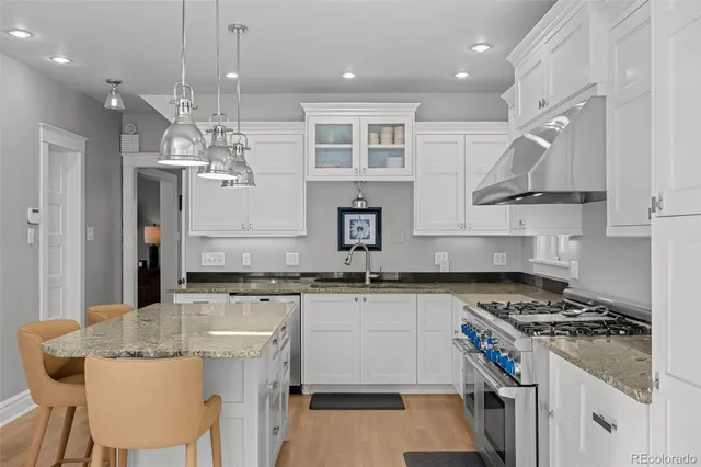 a kitchen with stainless steel appliances granite countertop a stove and a sink