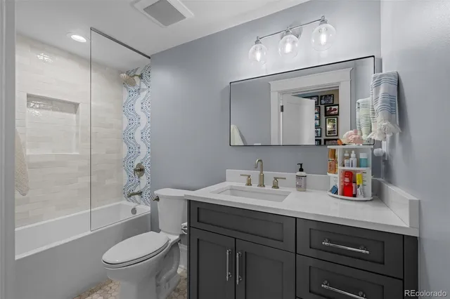 a bathroom with a sink vanity mirror and toilet