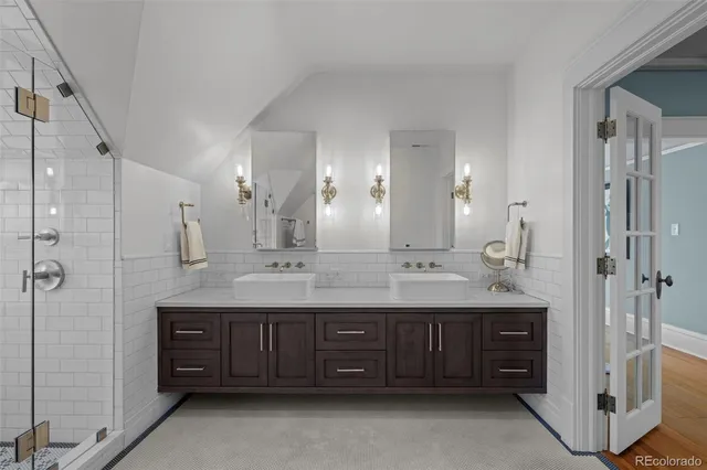 a bathroom with a double vanity sink mirror double and shower