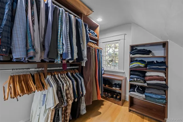 a view of walk in closet with clothes and shoes
