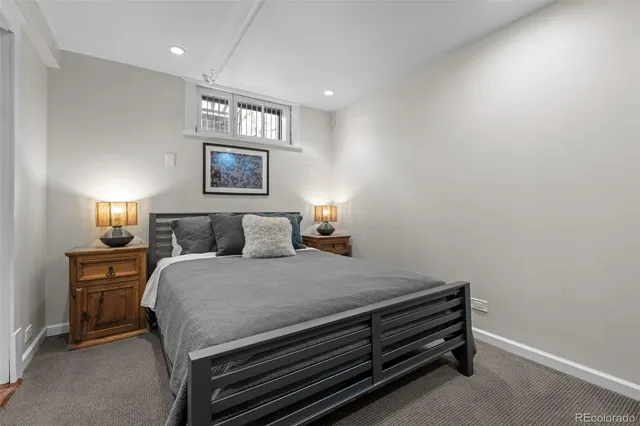 a bedroom with a bed and a lamp on dresser