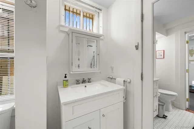 a bathroom with a sink toilet and a mirror