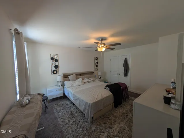 a spacious bedroom with a bed and a chandelier