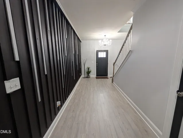 a view of a hallway with wooden floor and staircase