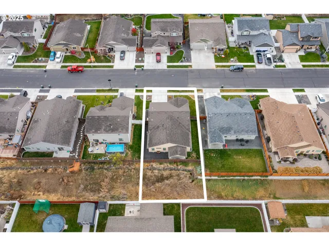 a view of a white house with a yard and garage