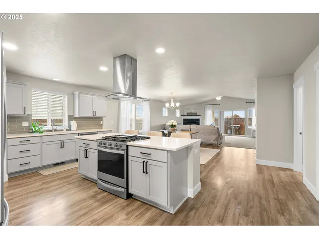 a kitchen with a stove cabinets and wooden floor