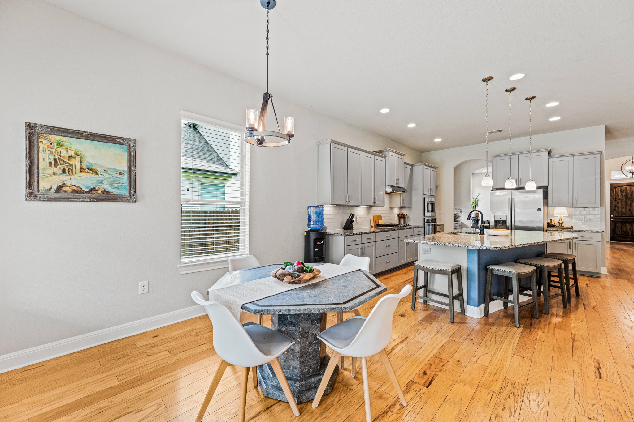 108 Redtail Lane Leander, TX 78641 - Photo 12 of 39 Hardwood floors and recessed lighting elevate this open-concept kitchen and dining area.