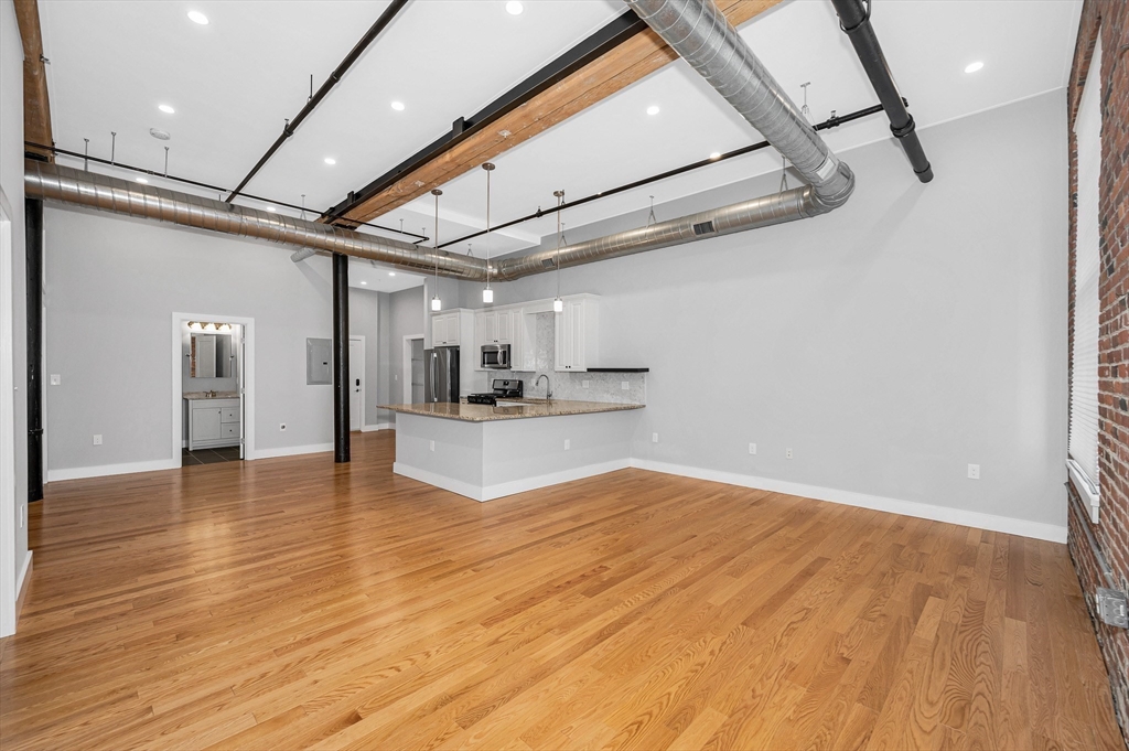 491 Dutton Street, Unit 320 Lowell, MA 01854 - Photo 13 of 31 a view of empty room with wooden floor