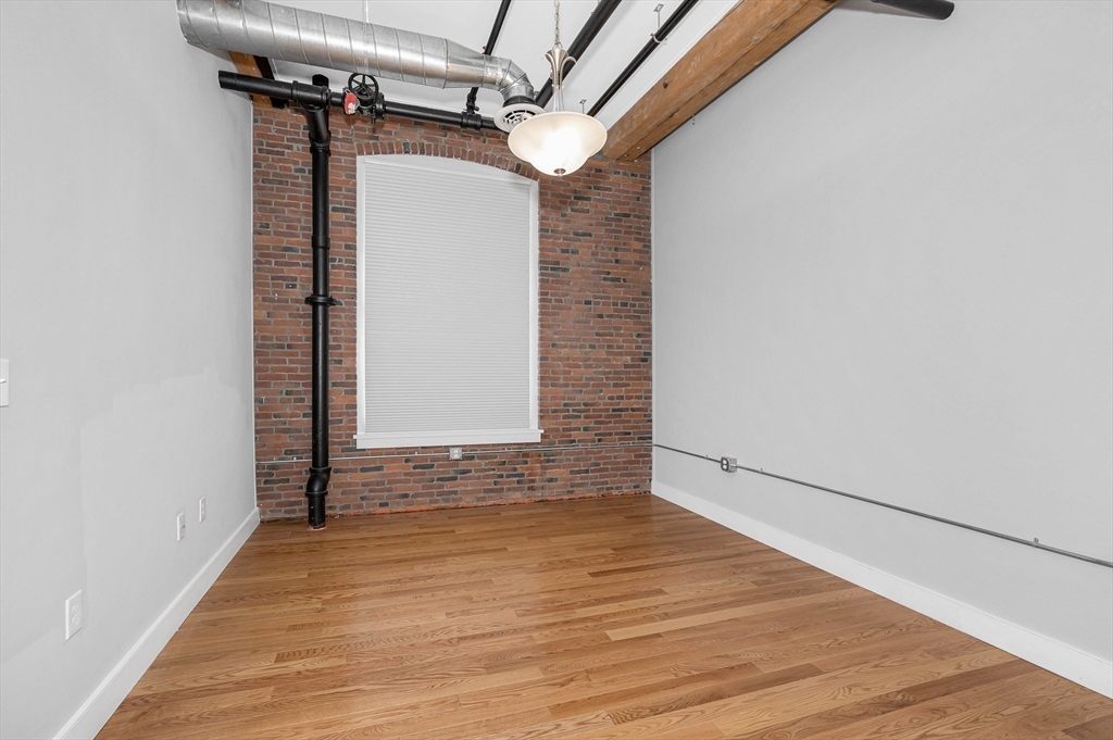 491 Dutton Street, Unit 320 Lowell, MA 01854 - Photo 14 of 31 a view of a room with wooden floor and a window