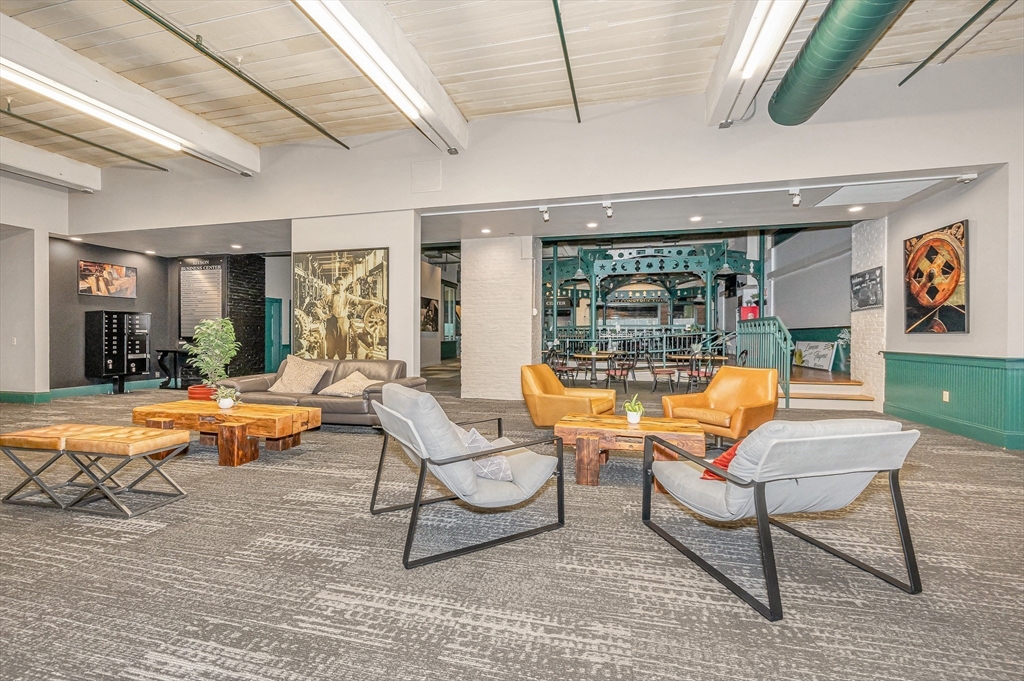 491 Dutton Street, Unit 320 Lowell, MA 01854 - Photo 29 of 31 a living room with patio furniture and a floor to ceiling window