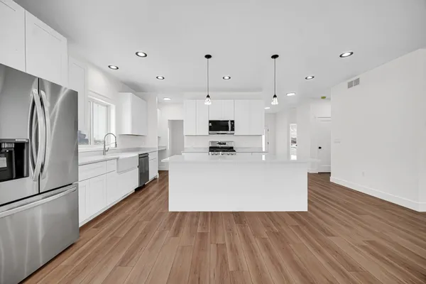 a view of empty room with wooden floor and ceiling fan
