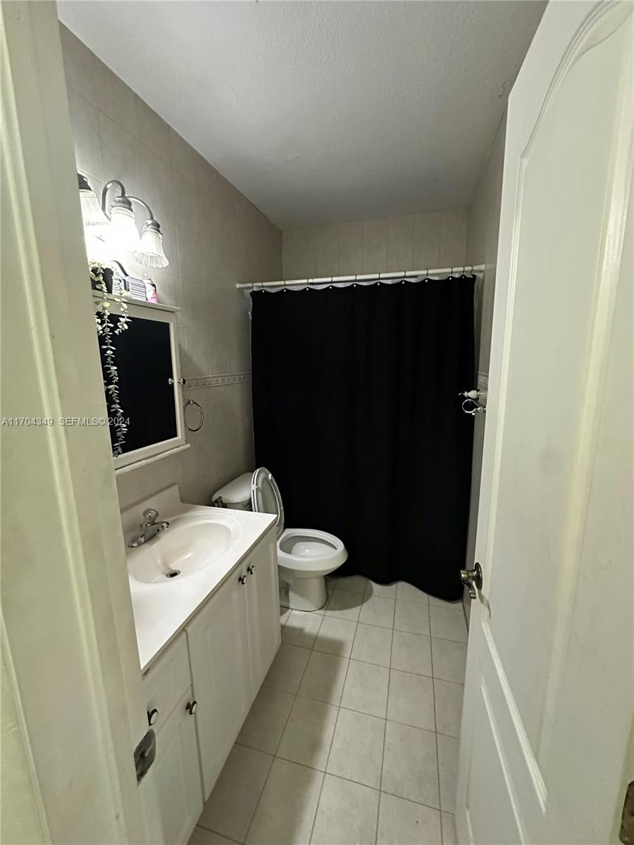 1838 Northwest 18th Street Miami, FL 33125 - Photo 9 of 22 a bathroom with a sink a toilet a mirror and shower
