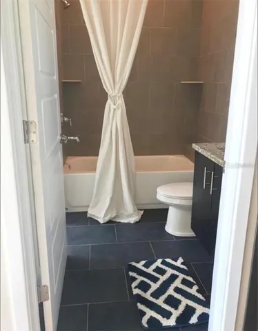 a bathroom with a sink a toilet a tub and shower