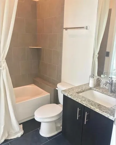 a bathroom with a granite countertop sink toilet and shower