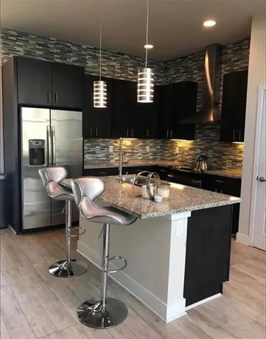 a kitchen with kitchen island granite countertop a stove and a wooden floor