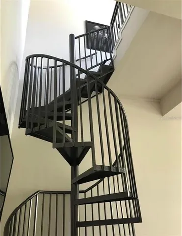 a view of staircase with wooden floor and white walls