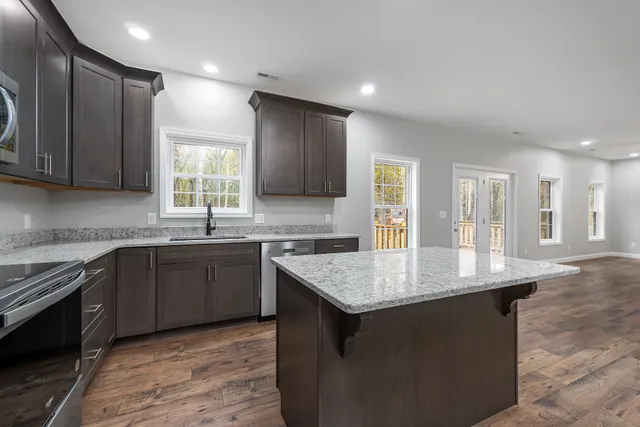 a kitchen with granite countertop a sink counter top space and cabinets