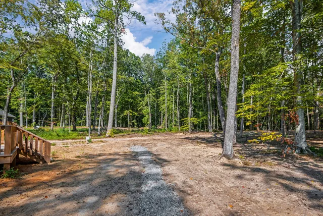 a view of a house with a yard and lawn chairs under an umbrella