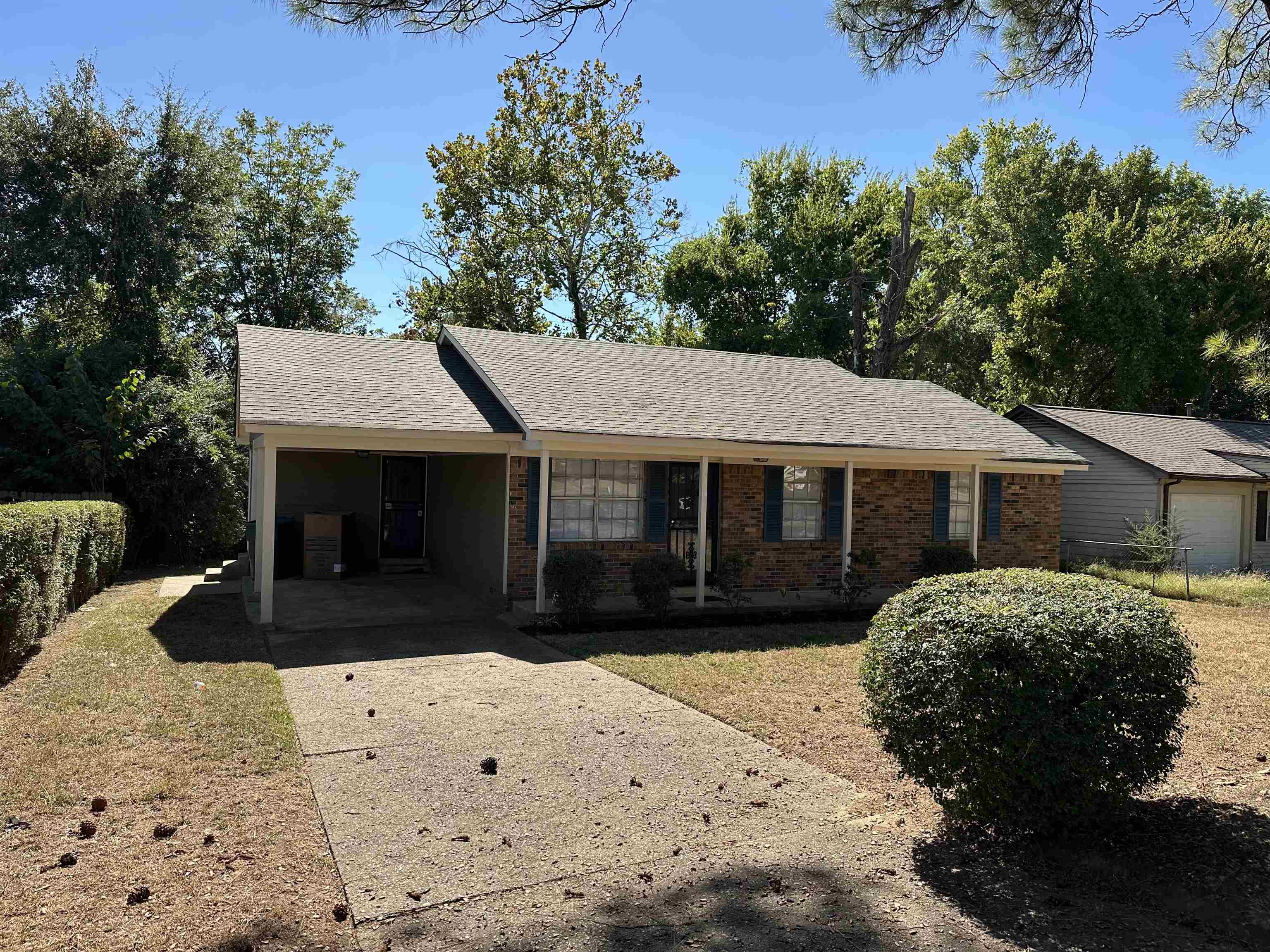 899 West Raines Road Memphis, TN 38109 - Photo 3 of 14 Brick exterior with a covered front porch, asphalt shingle roof, and a concrete driveway
