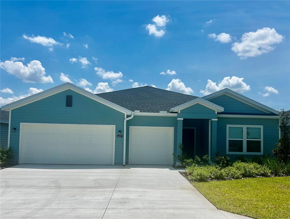 a front view of a house with a yard and a garden