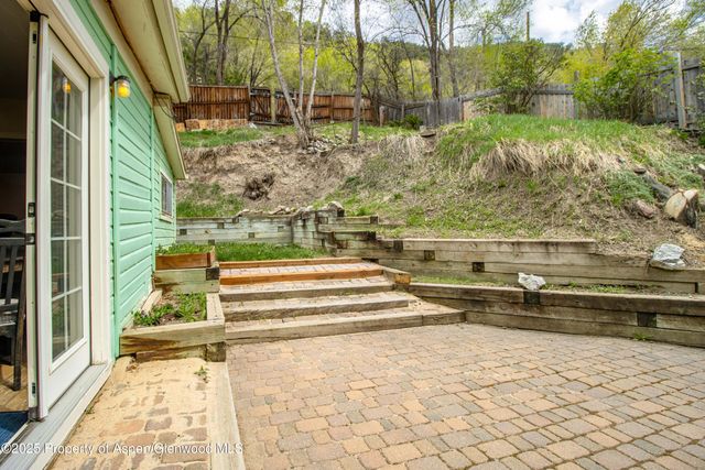 a view of backyard with large trees and plants