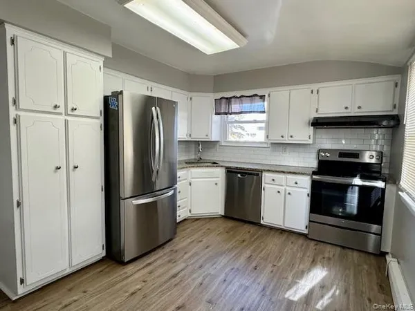 a kitchen with a refrigerator stove and wooden floors