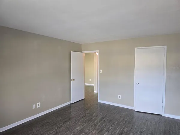 a view of an empty room with wooden floor