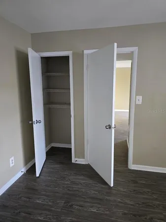 an empty room with wooden floor and closet