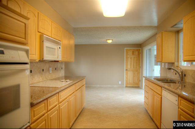 1770 Wren Street Reno, NV 89509 - Photo 3 of 9 a kitchen with stainless steel appliances granite countertop a sink a stove and a refrigerator