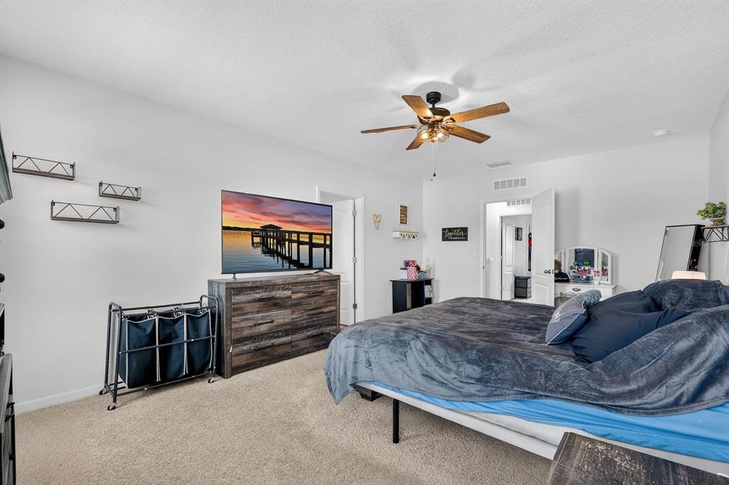 1809 Myrtlebrooke Drive Edgewater, FL 32141 - Photo 18 of 58 a bedroom with a bed and a chandelier